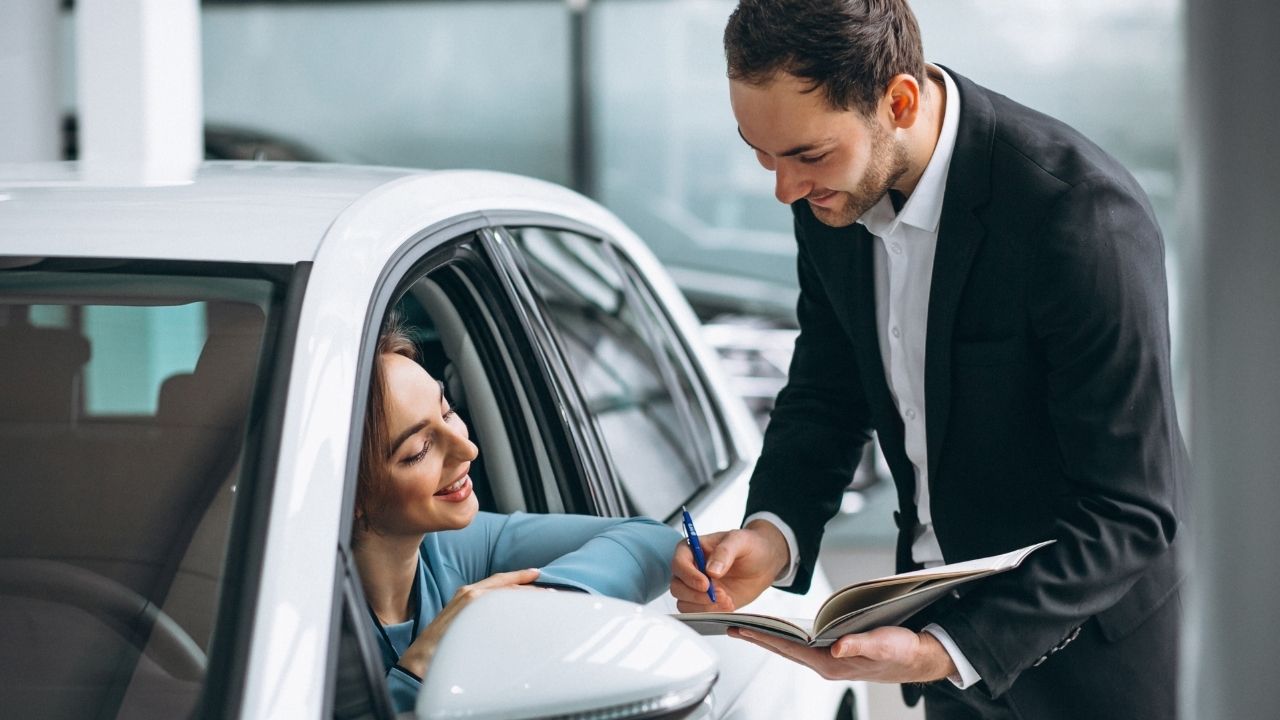 Woman inside a car reading a document shown by a man standing outside the car