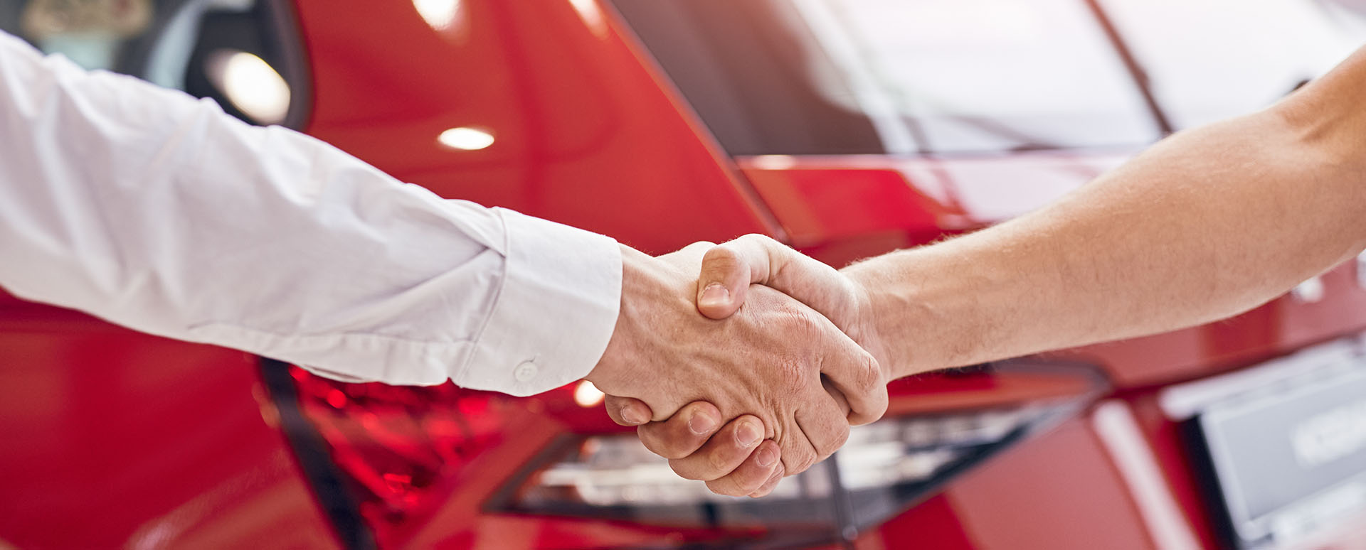 Shaking Hands In Front of Car