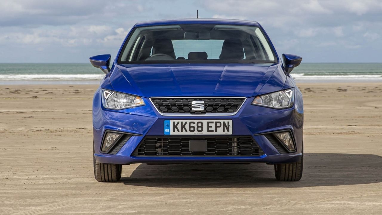 Blue SEAT Ibiza parked in front of the ocean