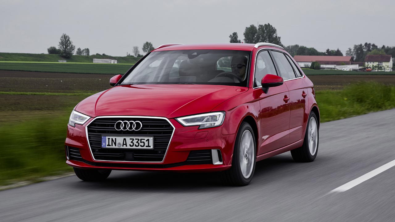 Red Audi A3 driving down a country road