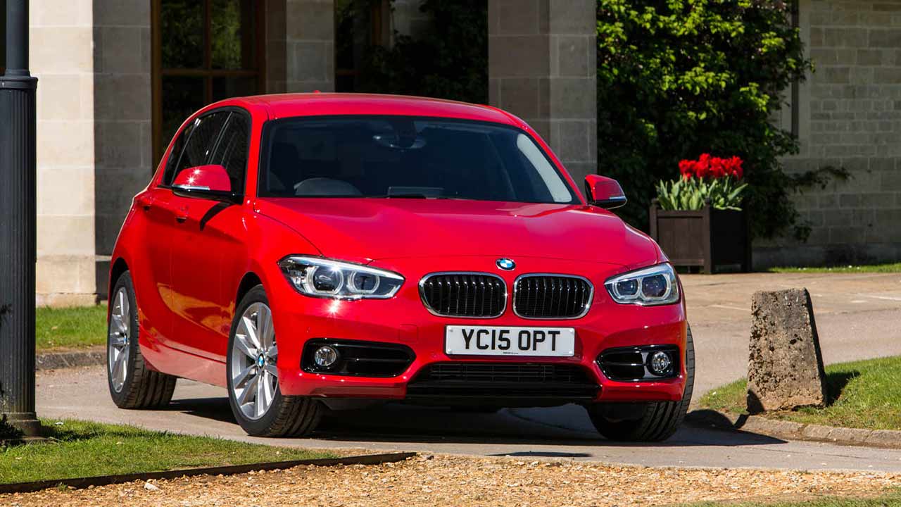 Red BMW 1 Series parked outside a country house