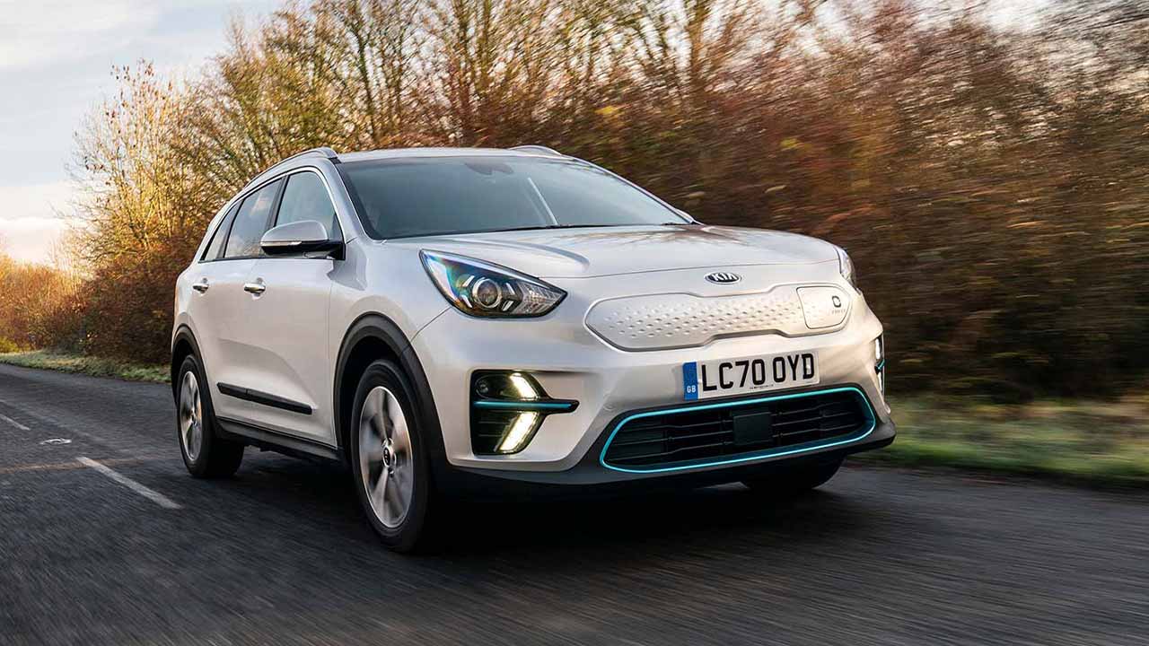 Silver Kia e-Niro driving down a country road