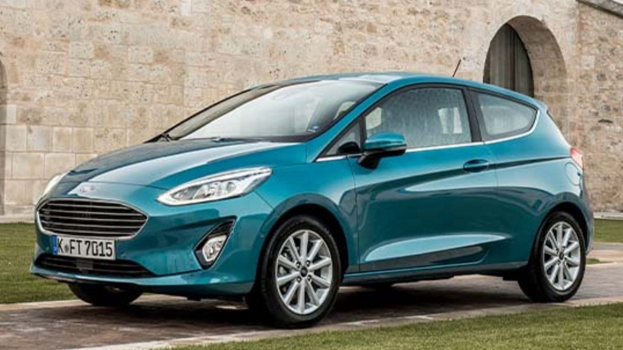 Blue Ford Fiesta parked in front of a brick wall