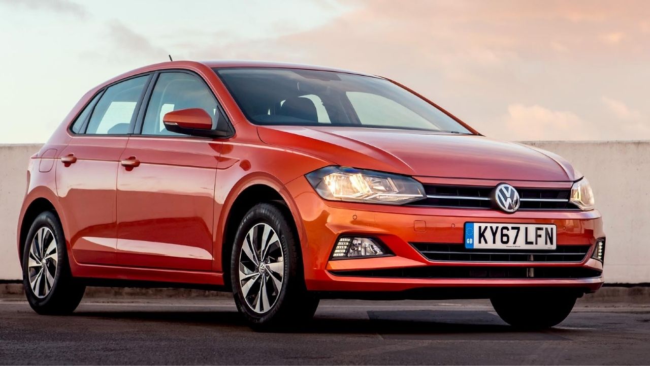 Orange Volkswagen Polo parked in front of a white wall